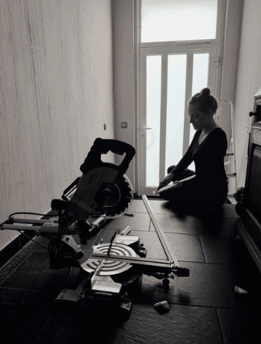 Sabrina Küppers arbeitet konzentriert mit einer Kappsäge in einer Wohnung